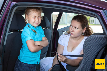 Mother trying to ask a girl get in child safety seat against the wishes